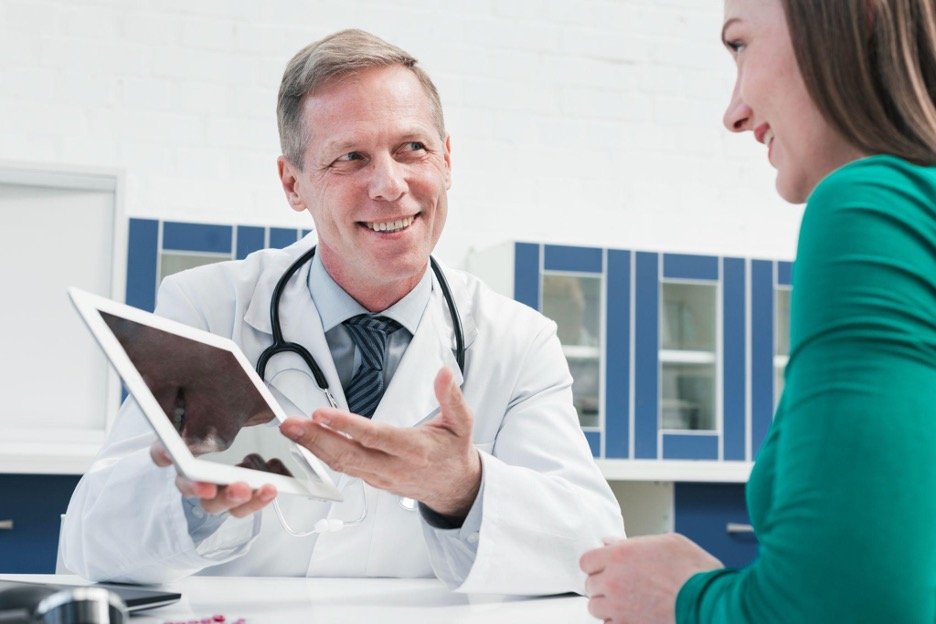 Doctor showing a tablet to a patient in clinic